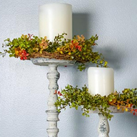 Rustic candle sticks with white candles and colorful wreaths