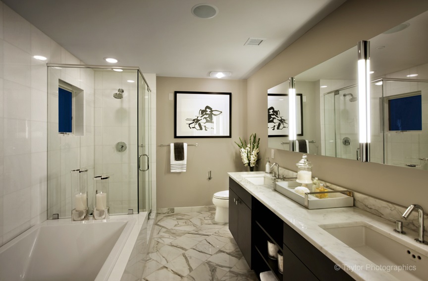 Large bathroom with double sinks on the right, bath and shower on the left, and a ceiling-mounted exhaust fan.