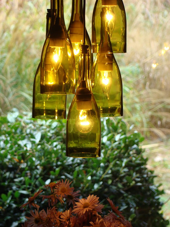 Six-light wine bottle chandelier with garden in the background