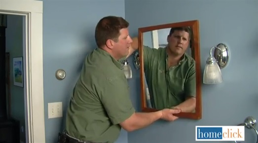 Man hanging mirror